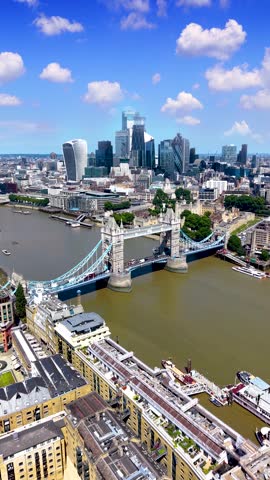 Establishing aerial view of the skyline of London, England, with Tower Bridge, River Thames and City skyscrapers during a summer day