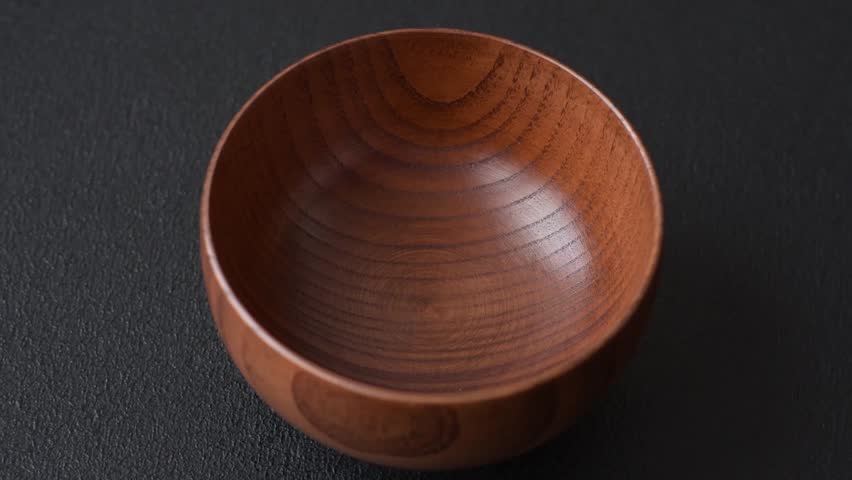 An empty round brown wooden bowl for Asian food. An empty wooden bowl