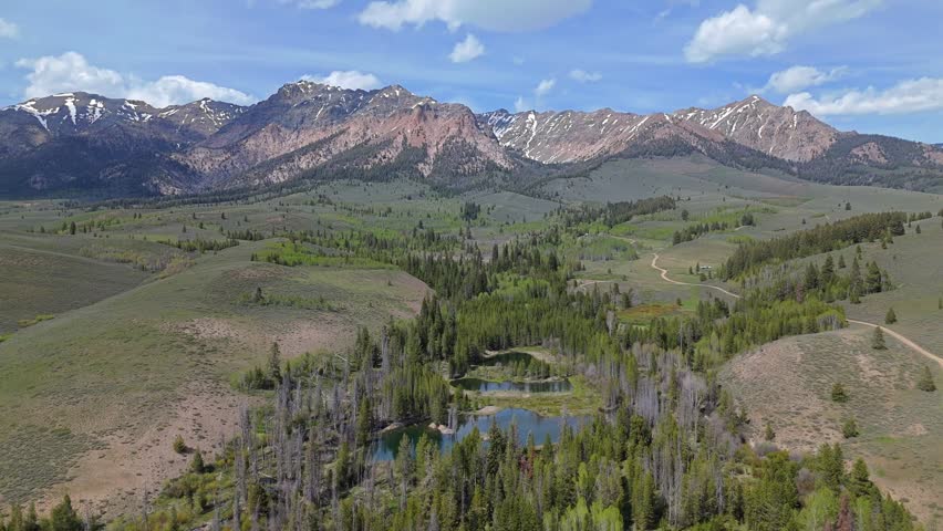Aerial orbit shot of Boulder Mountains in the Sawtooth National Recreation Area, Idaho on a sunny day in spring.