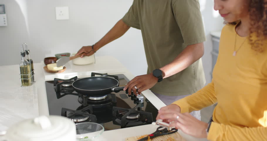 Couple preparing meal at counter man turning burner knob melting butter in pan woman peeling carrot. Kitchen, cooking, duo, stove, prep, oil, bowls