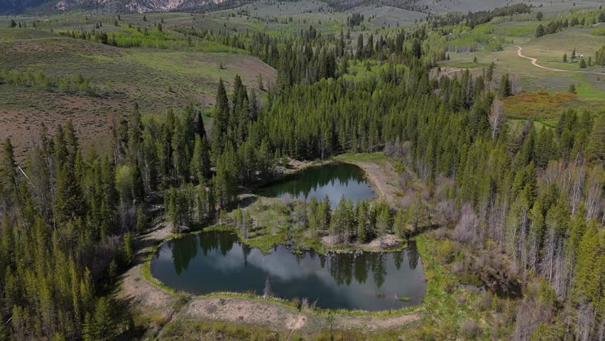Aerial crane shot of Boulder Mountains in the Sawtooth National Recreation Area, Idaho on a sunny day in spring.