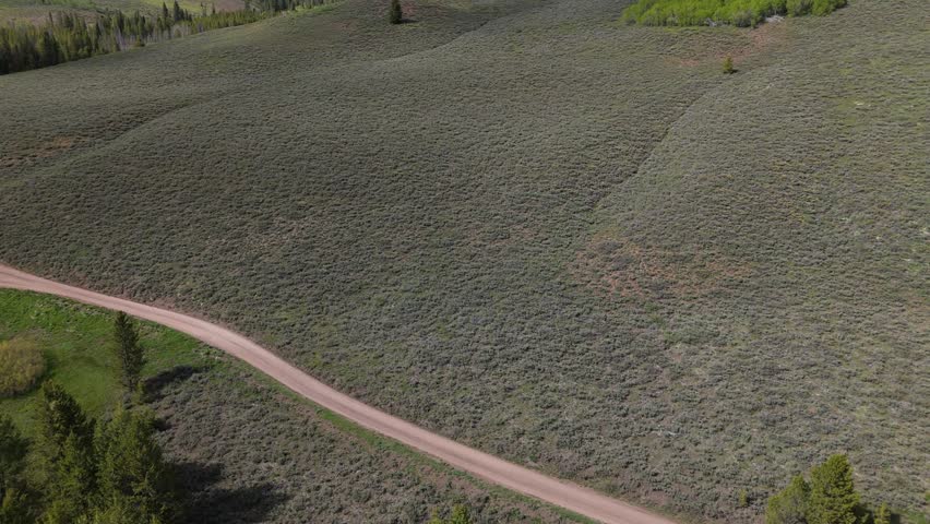 Cinematic aerial reveal of Boulder Mountains in the Sawtooth National Recreation Area, Idaho on a sunny day in spring.