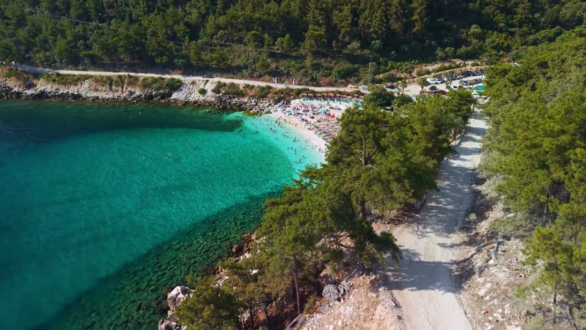 Aerial view of people swimming in amazing turquoise water at Marble Beach (Saliara) on a bright sunny day in Thassos, Greece. Iconic beach at Thasos island