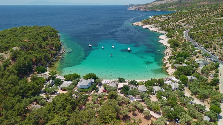 Drone perspective of the rocky Alyki peninsula nestled between turquoise bays with ancient ruins and lush greenery. Alyki beach, Thasos Island, Greece