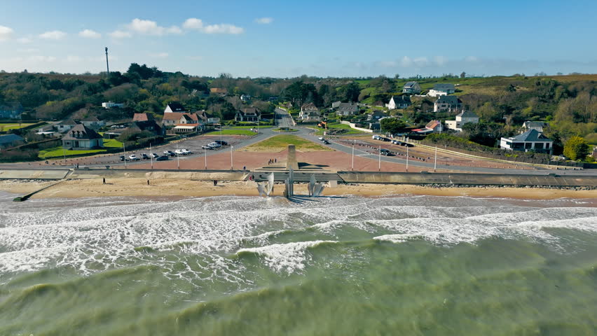 Omaha Beach in Normandy, France, with Les Braves memorial, shoreline and waves. Aerial drone view of historic D-Day landing beach
