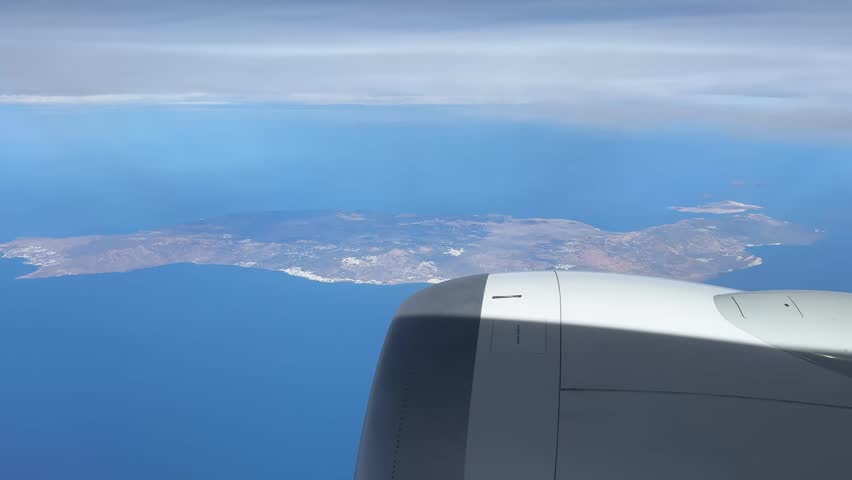 Commercial airplane engine above Atlantic ocean near Canary Islands coastline during international flight. Aerial travel landscape with blue sea horizon, clouds and island geography.