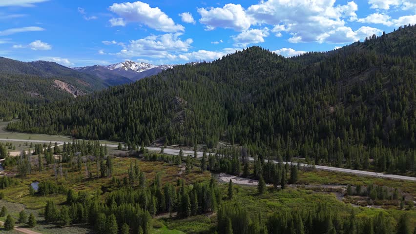 High aerial flyover shot of Sawtooth Scenic Byway in the Sawtooth National Recreation Area, Idaho on a sunny day in spring.