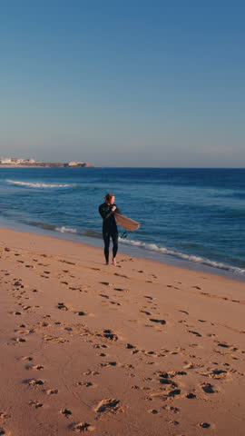Happy dog greeting surfer returning from Atlantic Ocean.

Emotional lifestyle moment as an excited corgi mix runs to welcome its owner after a surfing session at sunset.