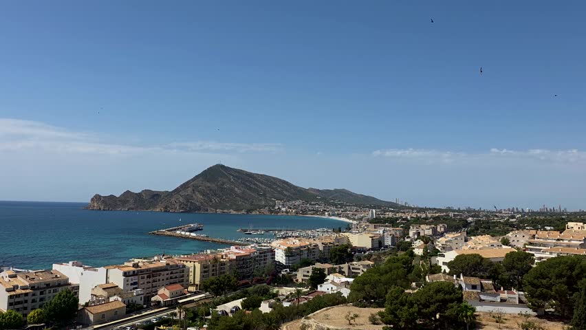 Slow motion aerial view of Altea old town white houses and Mediterranean sea coast in Alicante, Spain.