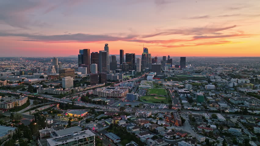 Sunset in Los Angeles. Drone view of Los Angeles skyline. Los Angeles, California aerial view cityscape. LA skyscrapers in dusk. Dramatic sky above LA skyline. Los Angeles towers at sunset.