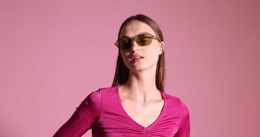 Beautiful woman in stylish sunglasses on pink background