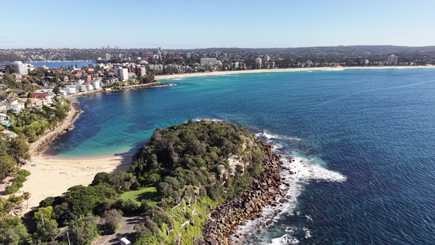 Aerial view of The Bower Manly featuring rocky headlands, sandy beach, and turquoise ocean waters along the coastline in Manly, New South Wales, Australia.