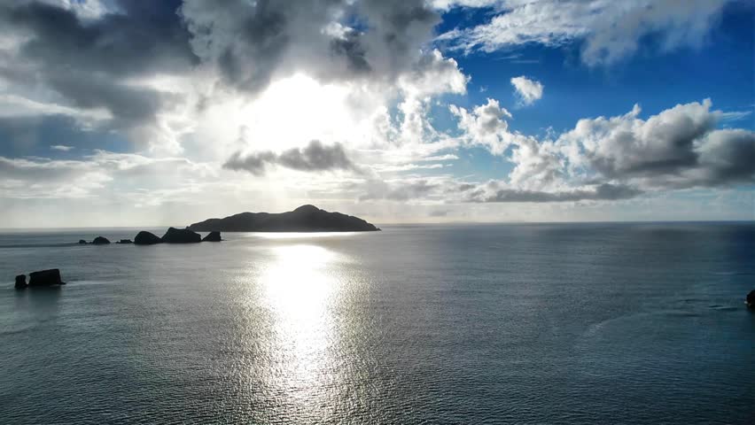 Sunlight reflecting on calm ocean at Kaminohama Coast in Okinawa, Japan
Drone aerial footage captured near Kaminohama Coast in Okinawa, Japan. Crystal clear turquoise waters, tropical islands, dramatic cloud formations, and beautiful coastal scenery viewed from above.