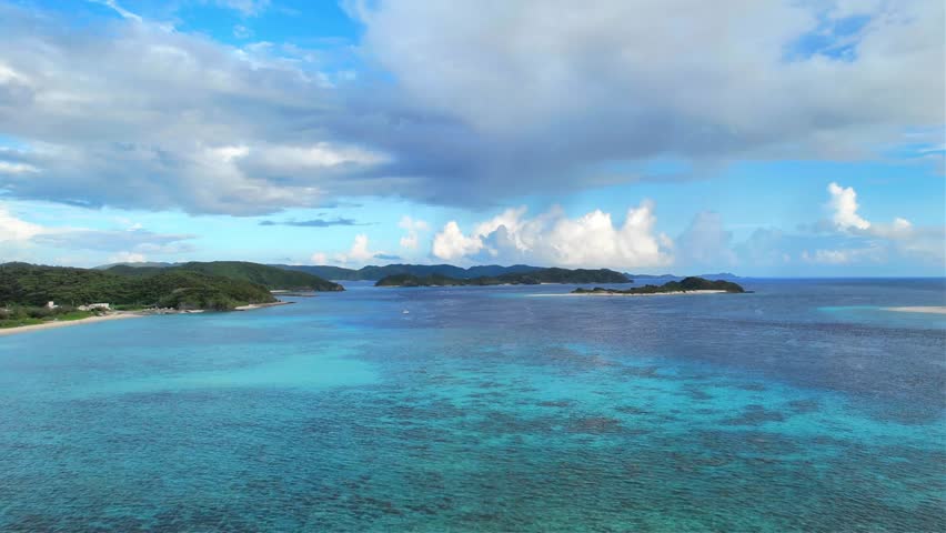 Crystal clear tropical sea and coastal landscape in Okinawa, Japan
Drone aerial footage captured near Kaminohama Coast in Okinawa, Japan. Crystal clear turquoise waters, tropical islands, dramatic cloud formations, and beautiful coastal scenery viewed from above.