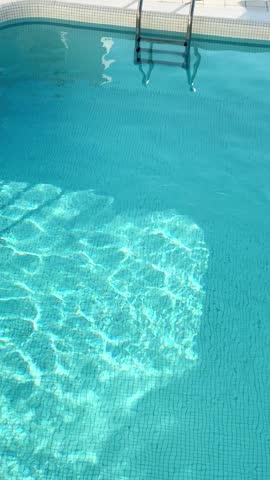 Santorini island, Greece. Luxury swimming pool with blue water. Travel and summer vacation concept. Vertical video
