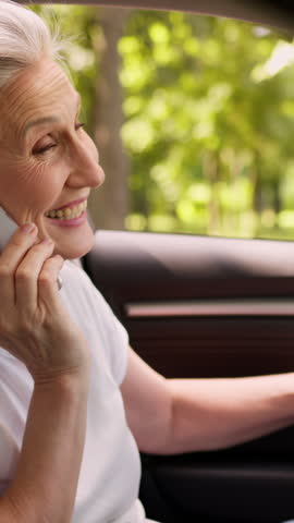 Happy Caucasian mature senior woman talking phone call get out of car old granny retired female driver smile laugh leaving auto talk mobile conversation smiling laughing chatting leave automobile