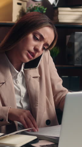 Dissatisfied Caucasian business woman leader with papers searching contract talking mobile phone female girl businesswoman project founder talk stressed search file stats documents throwing in office
