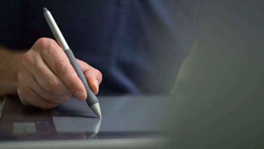 Graphic Designer Using Stylus Pen on Digital Drawing Tablet Close Up Professional video close-up of a designer