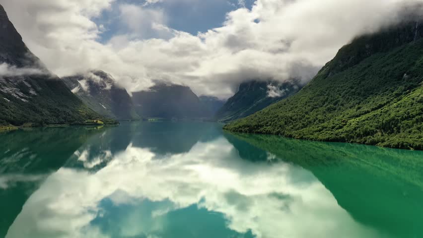 Aerial scenic fjord landscape with mountain reflections.