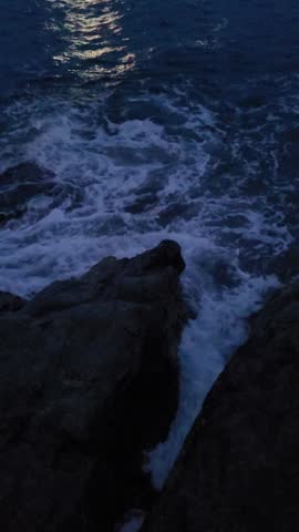 Crashing Waves Hitting Rocky Shoreline at Night