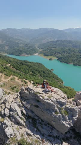 Albania welcomes you to Bovilla Reservoir, a picturesque escape perfect for tourism and holiday adventures. A couple of man and woman on top of a cliff looking out over the lake