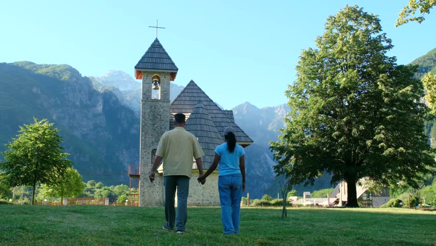 Albania Theth offers captivating views as visitors stroll toward a beautiful church nestled in the mountains. This perfect holiday destination is ideal for peaceful exploration