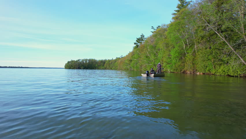 Beautiful lake Couchiching in Orillia Ontario Canada north of Simcoe Lake. Bass season opener. Motor boat with fishermen on water. Aerial view shot. Fishing boat and two anglers enjoying leisure.
