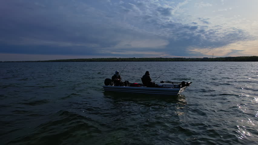 Beautiful lake Couchiching in Orillia Ontario Canada north of Simcoe Lake. Bass season opener. Motor boat with fishermen on water. Aerial view shot. Fishing boat and two anglers enjoying leisure.