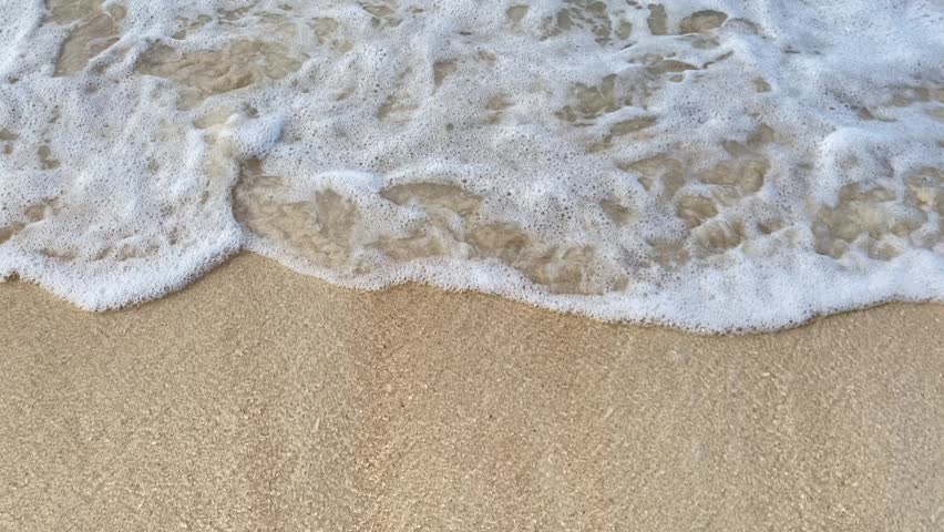 waves on the white sand of the beach