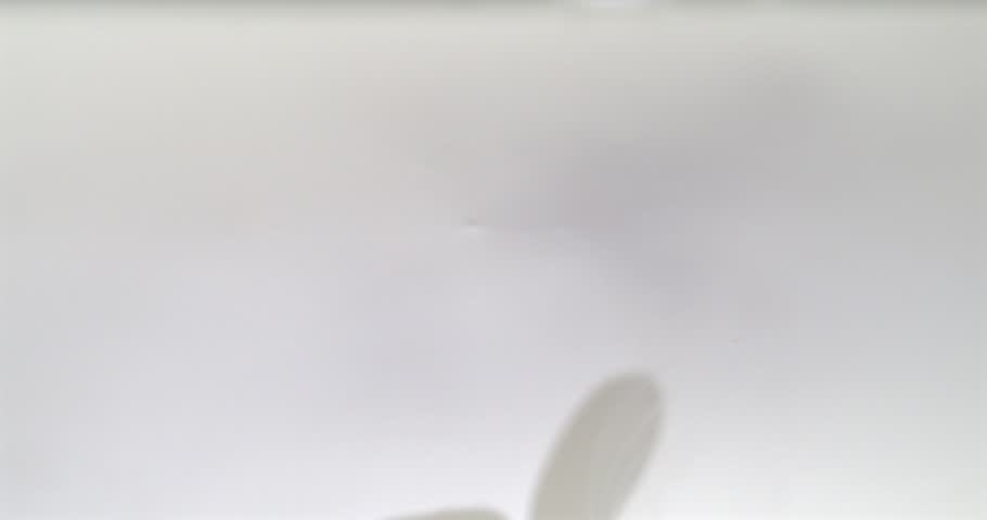 Almonds falling into milk with splash in super slow motion