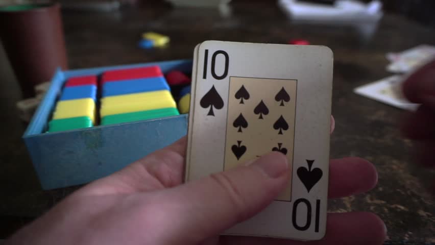 Hands holding playing cards reveal a winning poker hand of four aces and a ten
