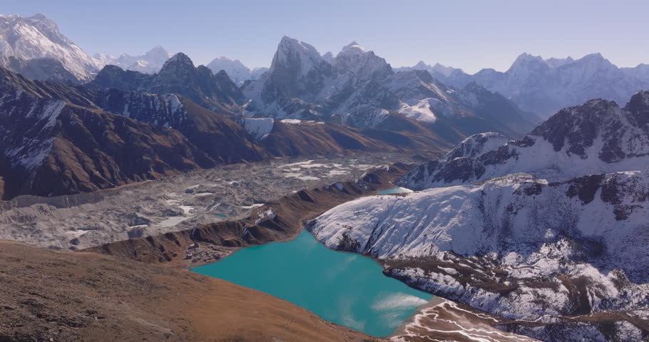 Gokyo Lake Everest region, Nepal, drone shot of the vibrant turquoise lake beneath rugged Ngozumpa Glacier and snow capped peaks of the Khumbu region.