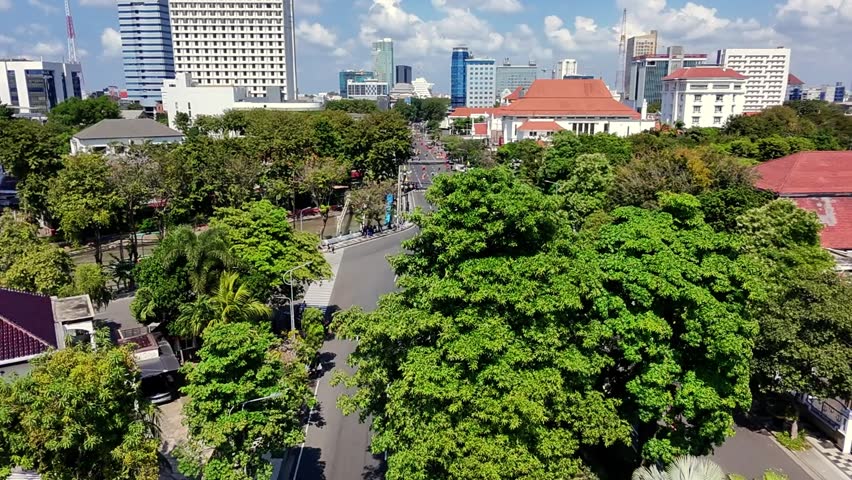 Aerial view of Surabaya City Hall (Balai Kota) and the surrounding urban landscape with city streets and green parks on a sunny day, East Java, Indonesia.