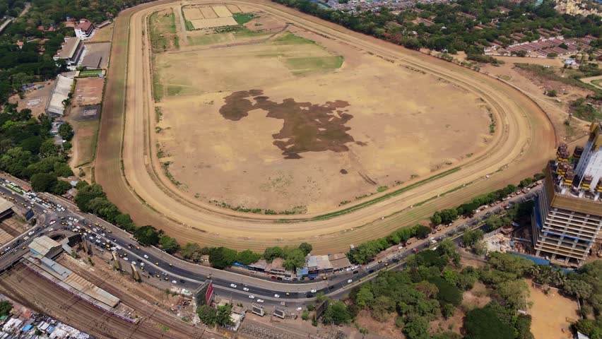 Expansive aerial view of the iconic mahalaxmi racecourse in mumbai, with the bustling cityscape, bandra worli sea link bridge, and the vast arabian sea creating a stunning urban panorama