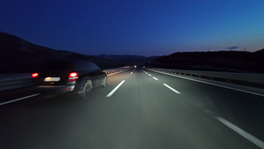 POV driving on modern highway with bright lights illuminating the road at night. Transportation, travel and infrastructure concept, 4k