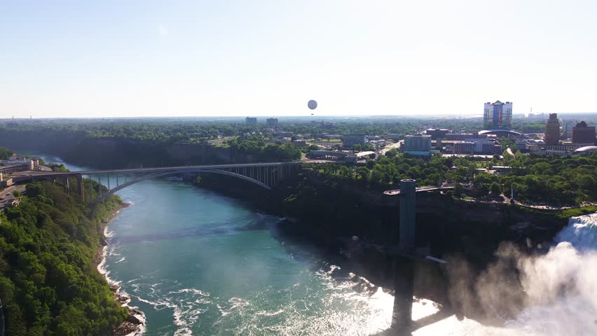 Aerial view of Rainbow Bridge spanning the Niagara River gorge with the surrounding Niagara Falls cityscape visible in the distance. Niagara Falls, Canada - June 13, 2026.