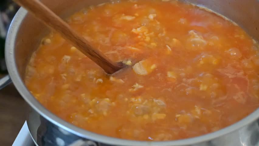 Close-up of egg barley with meat cooking in a pot, representing traditional Hungarian cuisine and home cooking process.