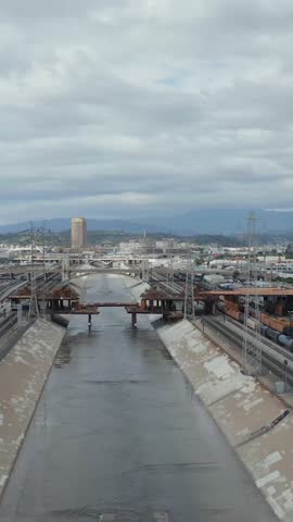 AERIAL: View over Los Angeles River Bridge Being Built under Construction Site with Overcast Cloudy Sky 
