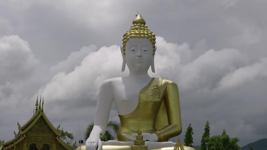 Beautiful Buddha Statue sitting against cloudy sky