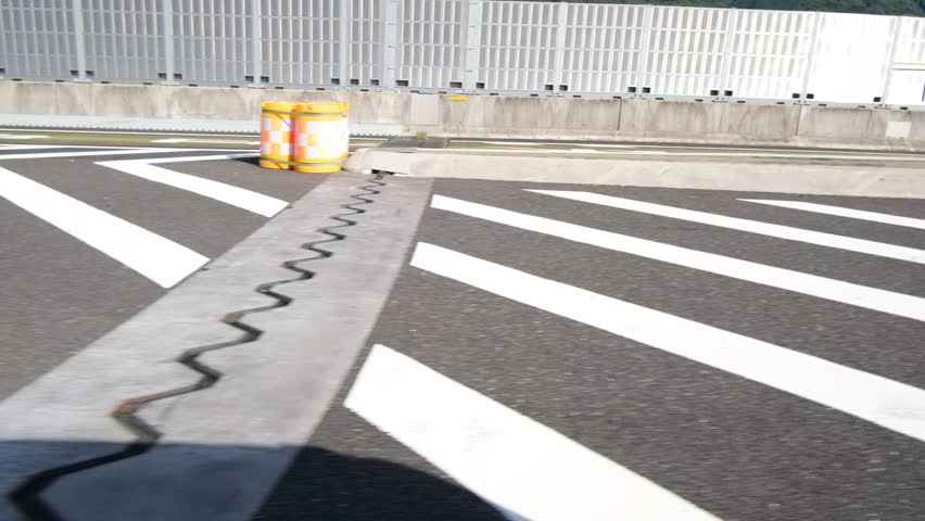 Abstract Road Markings and Red Traffic Cones Passing by Moving Car