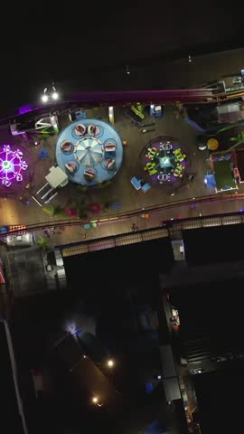 AERIAL: Breathtaking view on Santa Monica Pier at night with Ferris Wheel and colorful lights, 