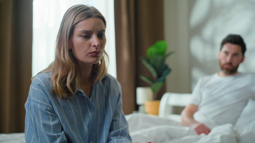 Offended Caucasian couple stressed separating on bed. Family intimacy problem sad upset woman wife with frustrated man husband ignoring separate in bedroom relationship psychological love trouble