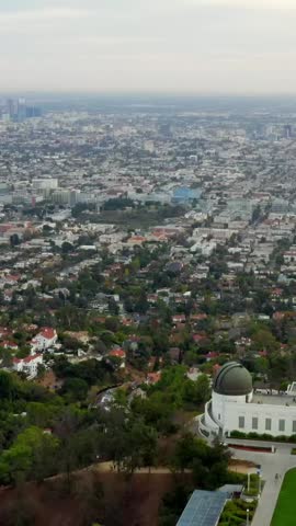 AERIAL: Over Griffith Observatory with Los Angeles, California Skyline in background in Daylight,Cloudy 