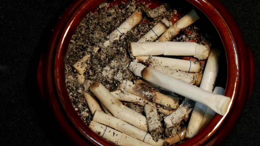 Extinguish a cigarette in an ashtray full of butt cigar stop smoking concept unhealthy lifestyle 4k