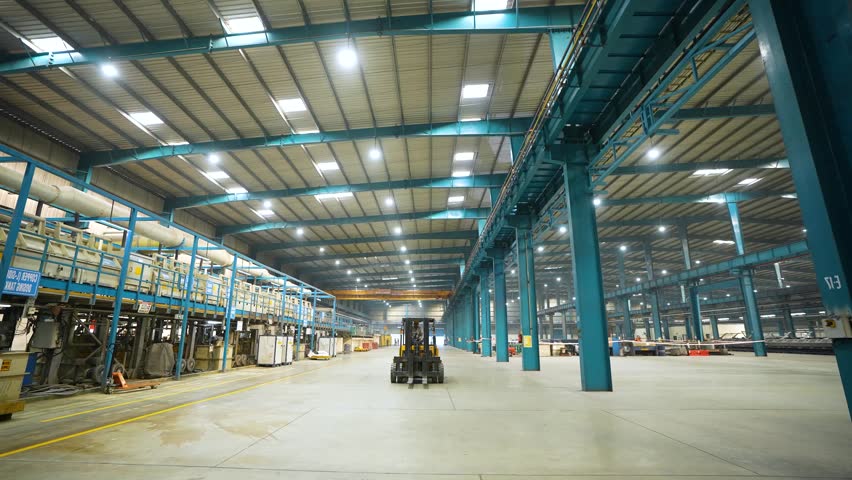 large factory inside, lifter moving inside the manufacturing plant. technical production factory. well lit production warehouse. 