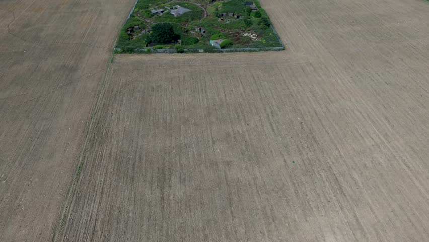WWII anti-aircraft battery at Chadwell Heath forward drone shot left to right over concrete gun pits, command posts and ruins in Essex, England, revealing RAF-era defences and landscape.