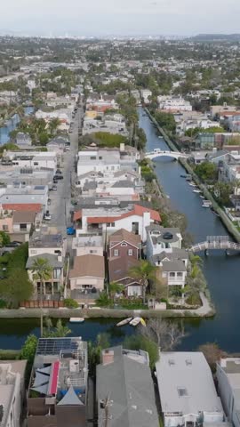 Aerial slider of Venice Canals surrounded by dense town development. Residential suburb of metropolis. Los Angeles, California, USA