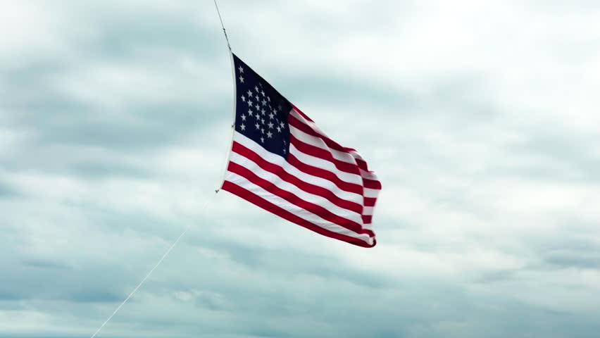 American flag at Fort Sumter blowing in a strong wind under cloudy skies