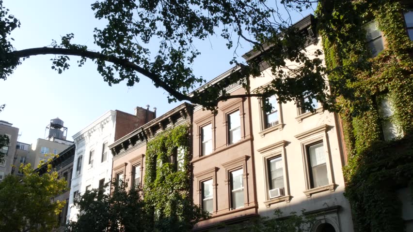 New York City townhouse buildings, brownstone row houses in Manhattan or Brooklyn, United States of America. Classic buildings on residential district street. Real estate property. Rowhouse townhome.