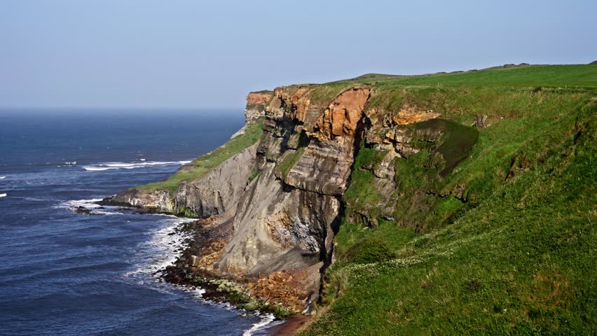 Eroding cliffs along the North Sea coastline near Whitby in the North York Moors National Park, United Kingdom